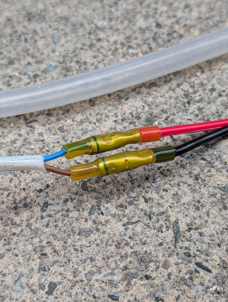 Step-down heat-shrink butt connectors joining the pump's 16 AWG leads to 14 AWG cigarette-plug wire