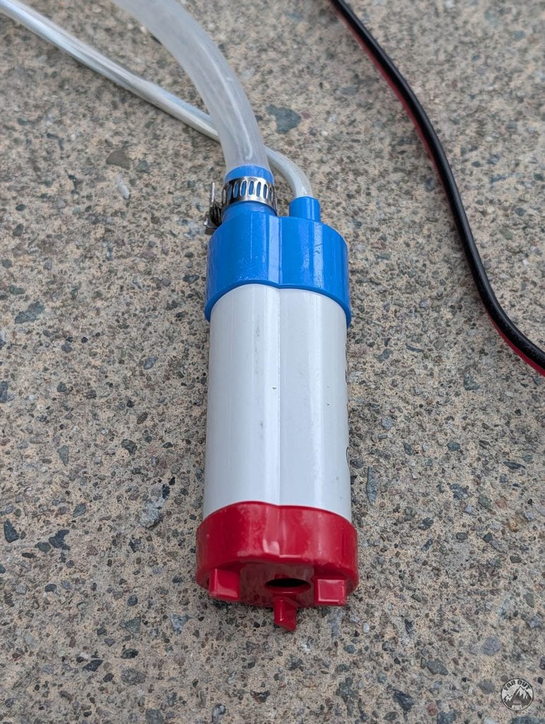 12V submersible transfer pump with 3/4 inch clear tubing clamped to its outlet