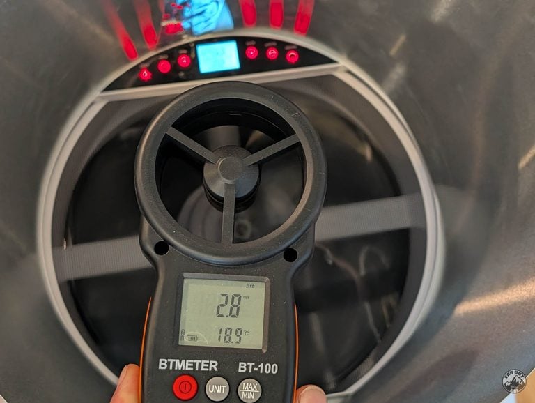 BTMETER BT-100 vane anemometer held inside the cylinder above the AirPlus fan, reading 2.8 m/s